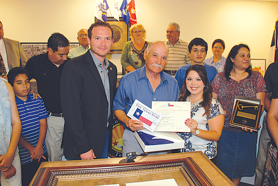 Surrounded by the Dominguez Family, (l-r center)Texas State Representative Oscar Longoria presents Mr. Manuel Dominguez with a framed state proclamation and a flag flown over the Capital held by Legislative Director Michelle Lee Villarreal.