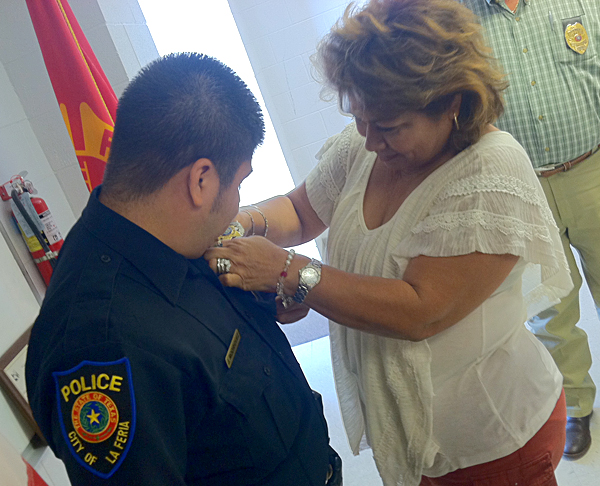 Blanca Rodriguez pins a badge on her son Officer Jesus Rodriguez
