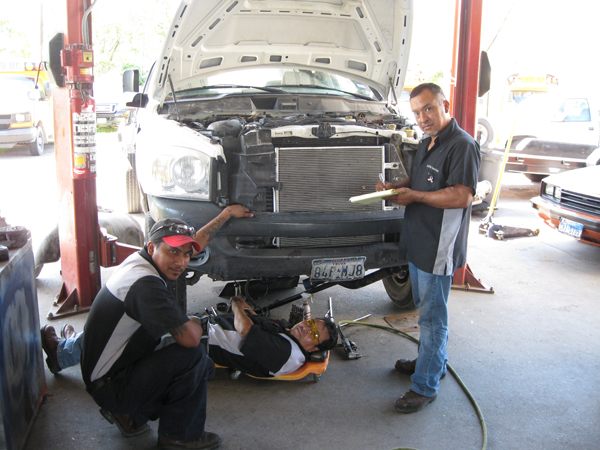Supervisor Julio Avila and certified technicians Aaron Gonzalez and Jose Reyes check out a customer’s vehicle. 