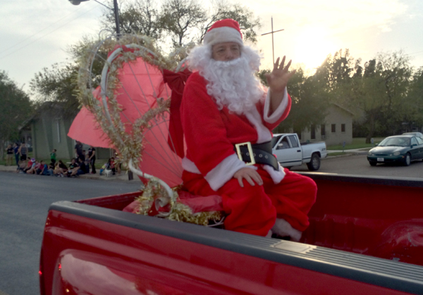 Santa Claus rode in the back of a red truck at the end of the parade.