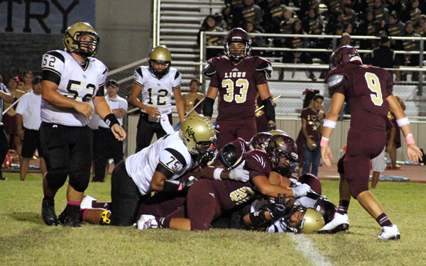 The Lion defense brings down the Brahma running back.