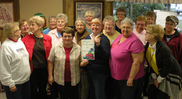 Members of the Ladies Quilt Project pose together during the presentation of the auction proceeds. 