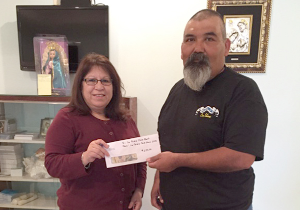 Olivia Robles,  Food Bank manager, accepts donations from Car Show volunteer Alvaro Sauceda.
