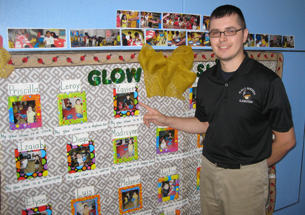 Science teacher Villarreal with exhibit of works by students