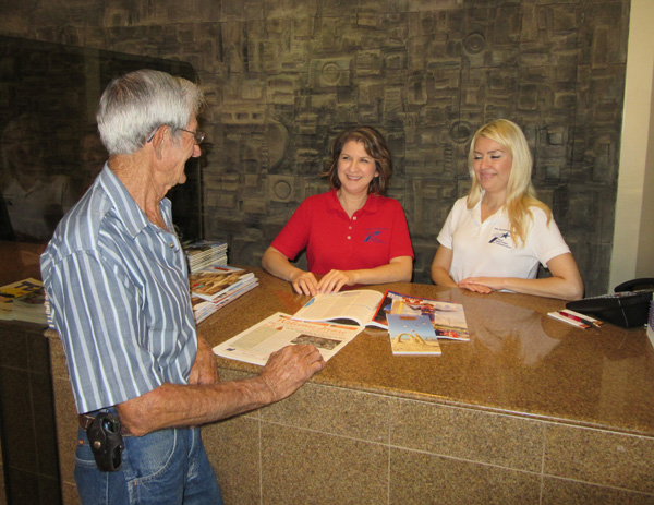 Travel  Counselors, Laura Chapa and Denise Martinez, help visitor Tom Pierce of Taylorville, Illinois, plan his visit. 